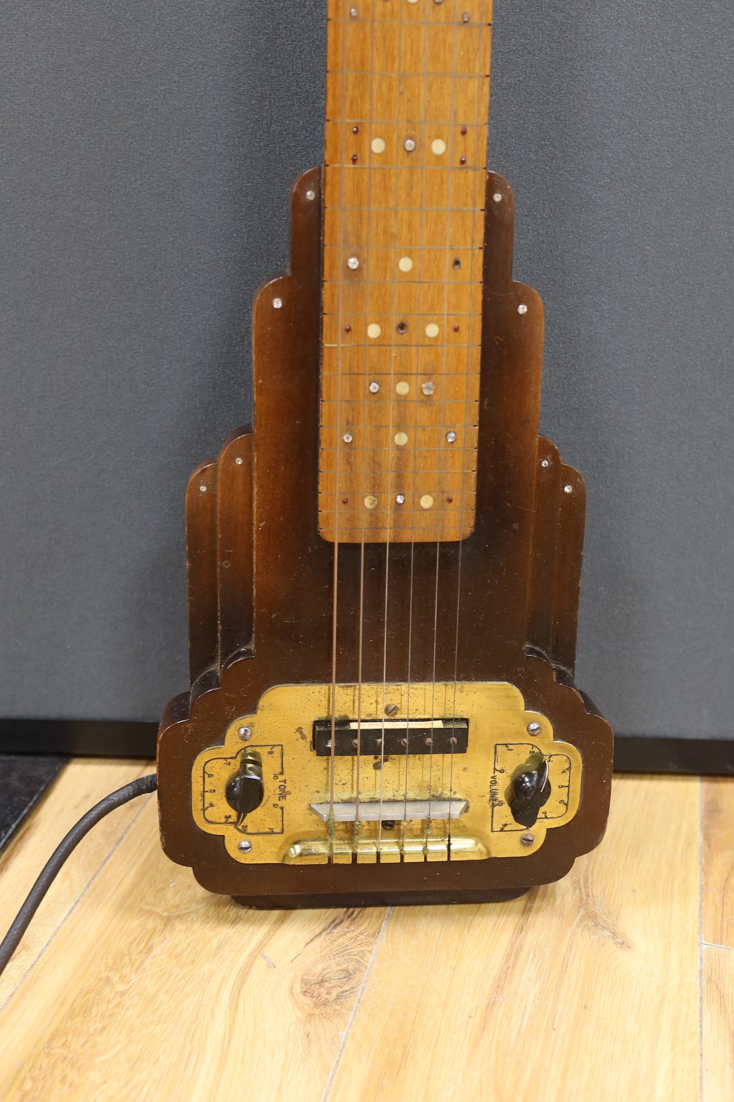 A steel guitar, the case, inscribed Haiwaians, 83cms high